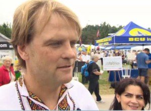 Chris Alexander at Ukraine Independence Day event in Toronto, Aug 2014. In background are red-black flags of Ukraine far-right